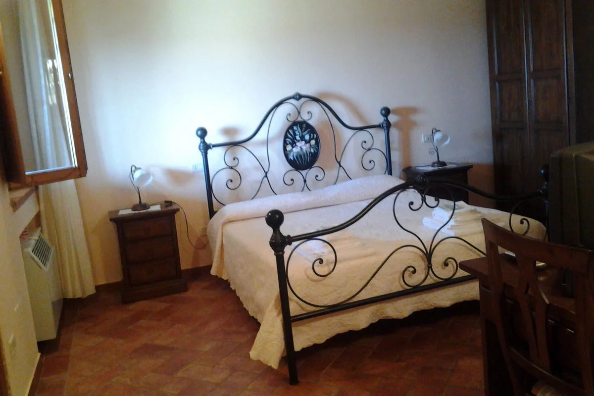 Camera matrimoniale con finestra e letto in ferro battuto