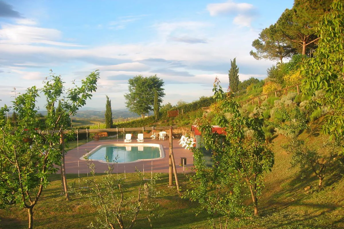 Piscina tra gli alberi del giardino e i cipressi