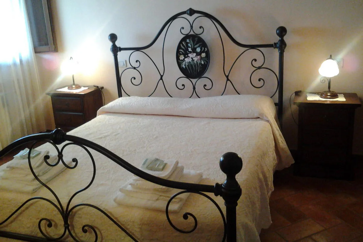 Letto matrimoniale con comodini e lampade