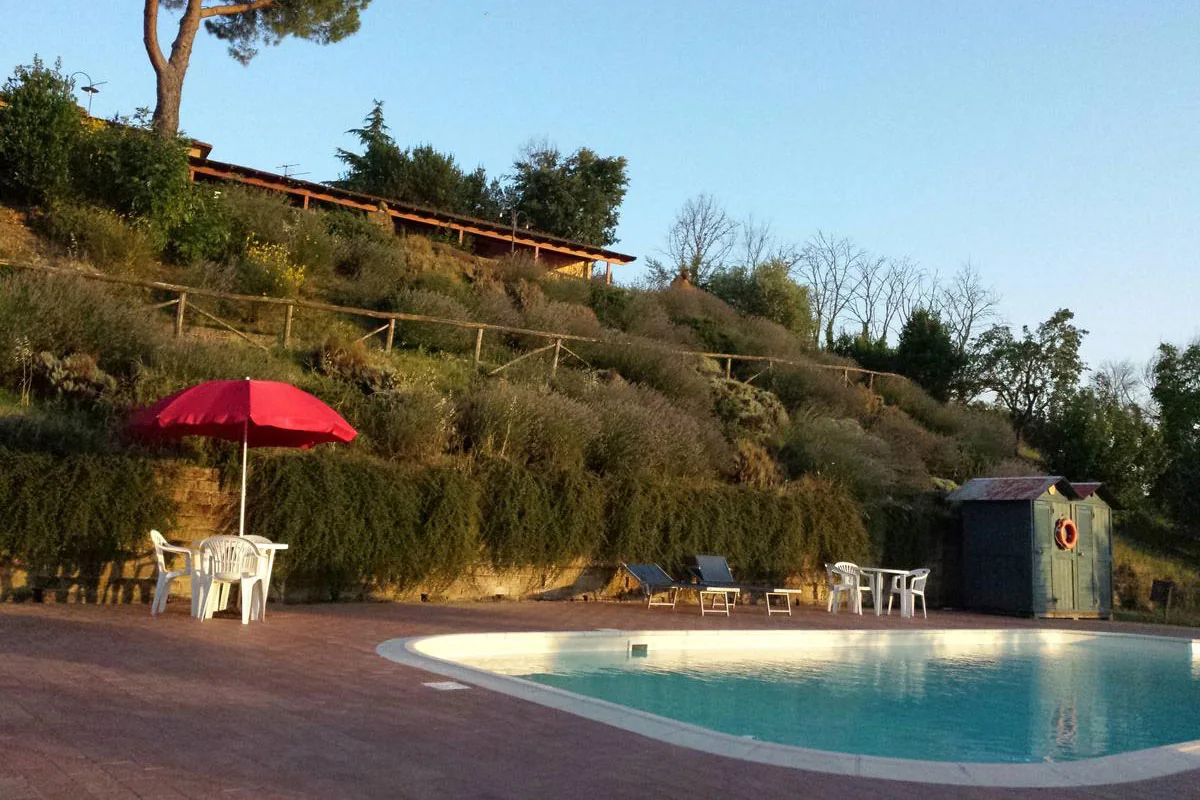 Piscina con ombrelloni e giardino terrazzato