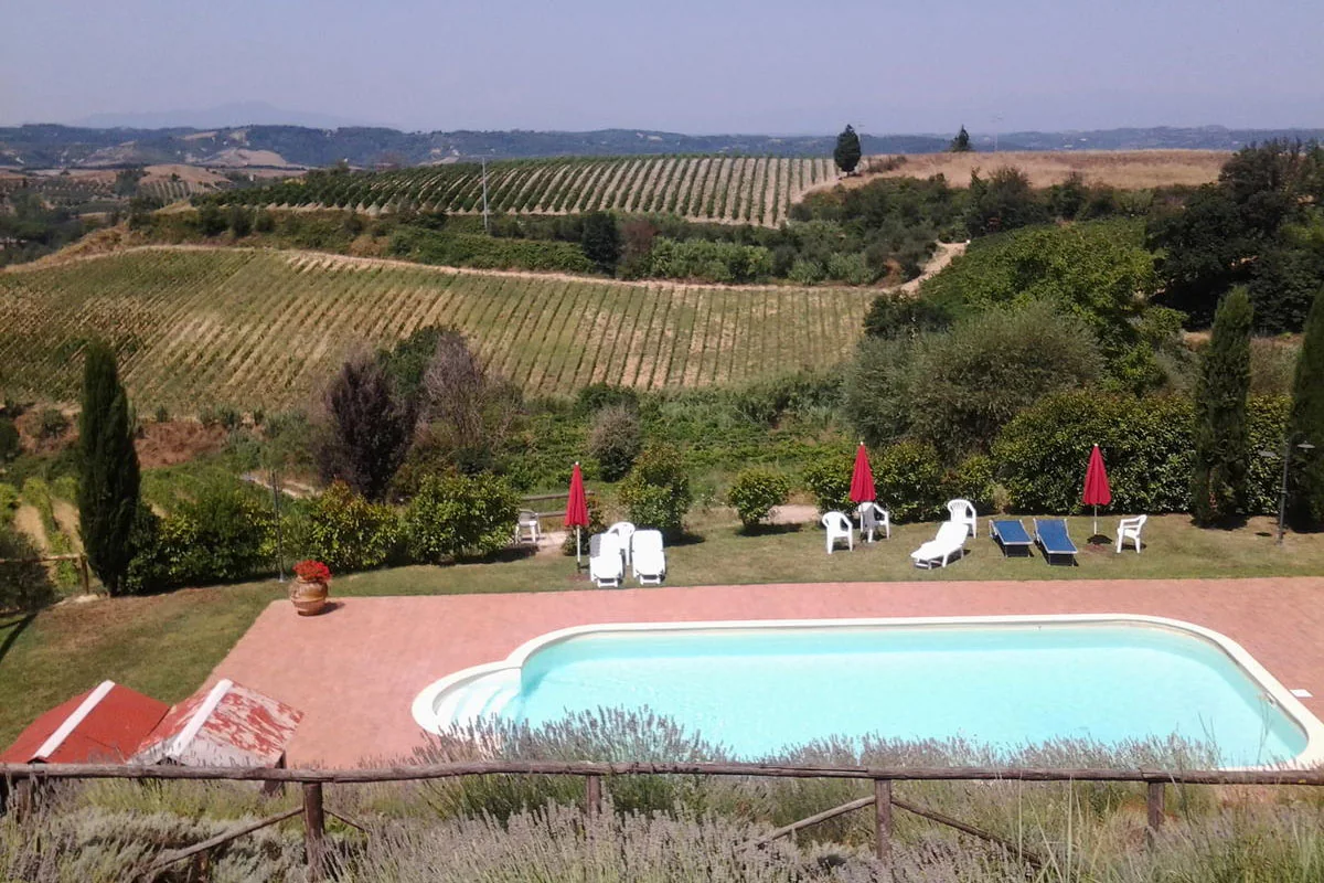 Piscina e solarium con panorama sui vigneti